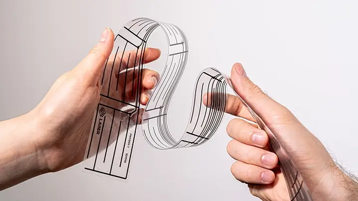 Holding a LAIIER printed tape sensor. Holding a LAIIER printed tape sensor.