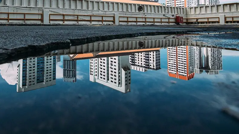 Flat roof buildings reflection in puddle 